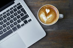 A coffee next to a laptop