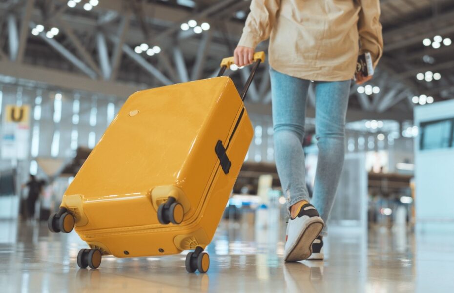 A woman pulling a suitcase through an airport.