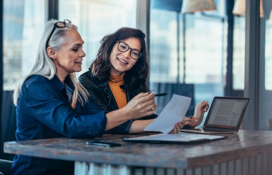A woman talking to a colleague in an office.