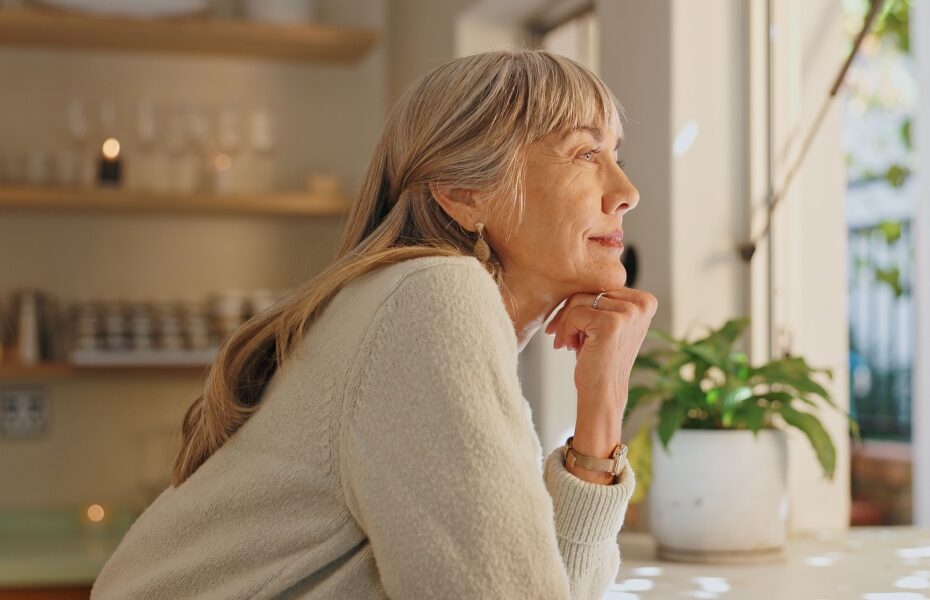 A woman looking out of the window at home.