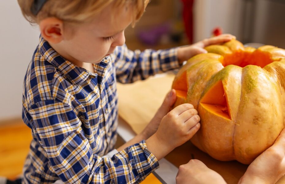 A child carving a pumpkin.