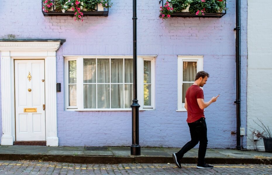 A man walking in front of a terraced house.