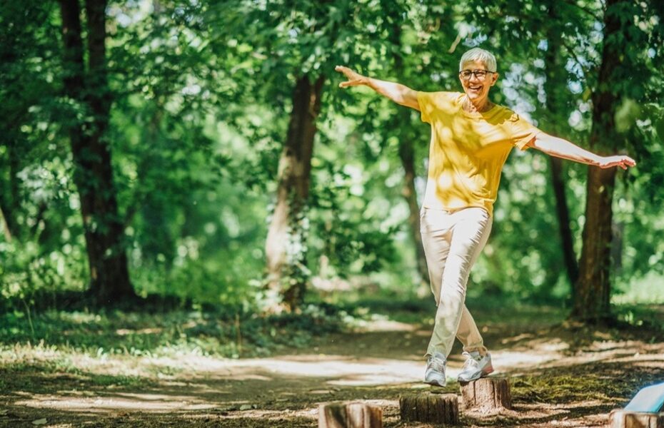 A woman doing balancing exercises outdoors.
