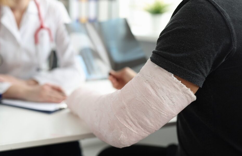 A man with a broken arm speaking with a doctor.