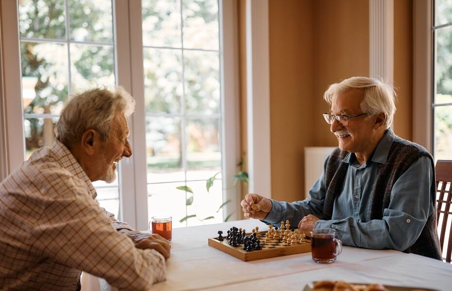 Two men playing chess at home.