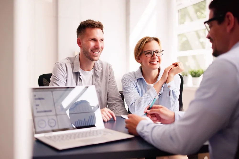 A couple happily talking with their financial planner.