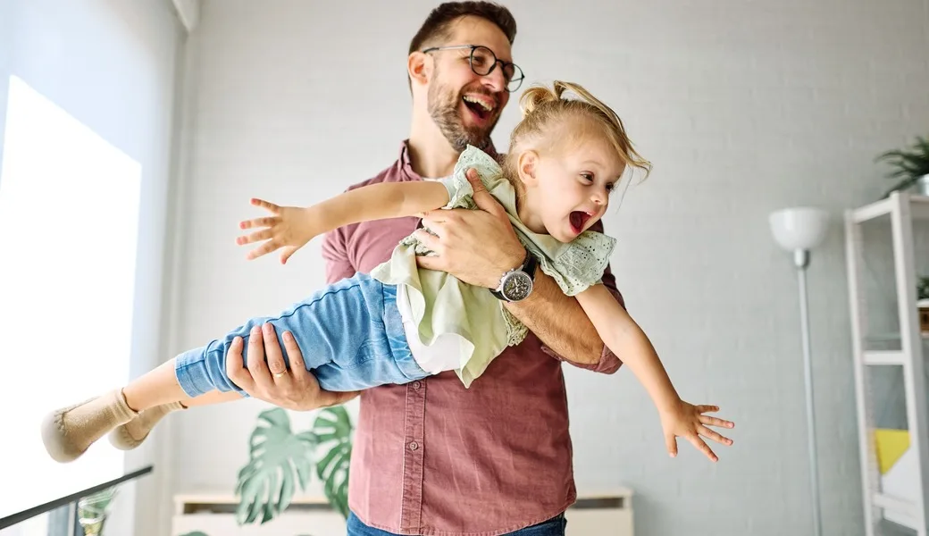 A father playing with his young daughter.