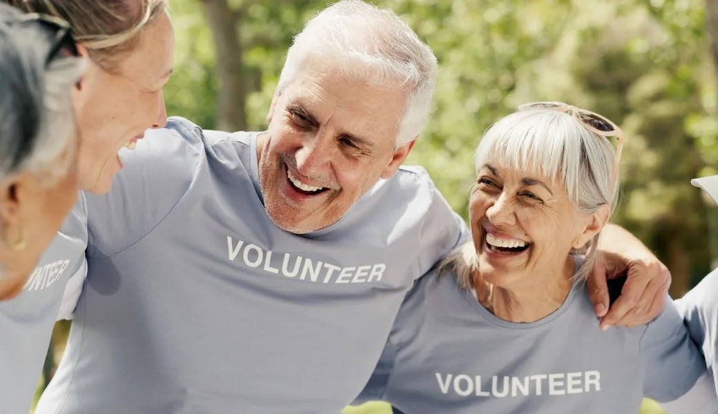 Happy senior people wearing “volunteer” t-shirts.