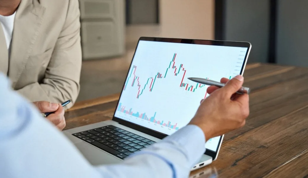 A man reviewing stock market movements on a laptop.