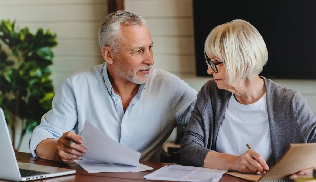 A mature couple talking and looking at paperwork together